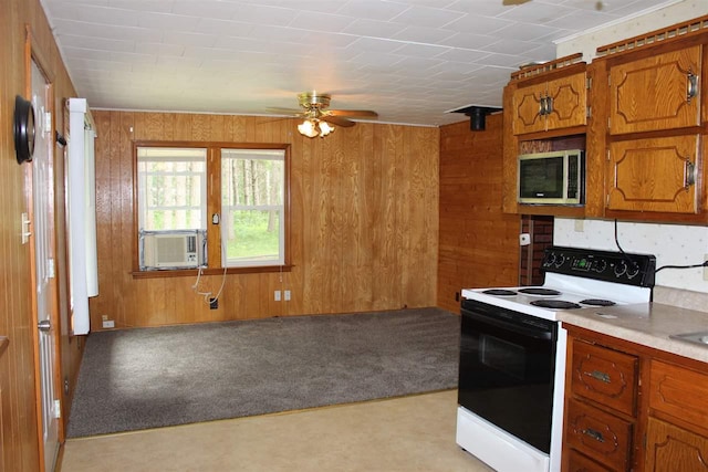kitchen featuring brown cabinets, cooling unit, range with electric cooktop, stainless steel microwave, and wooden walls