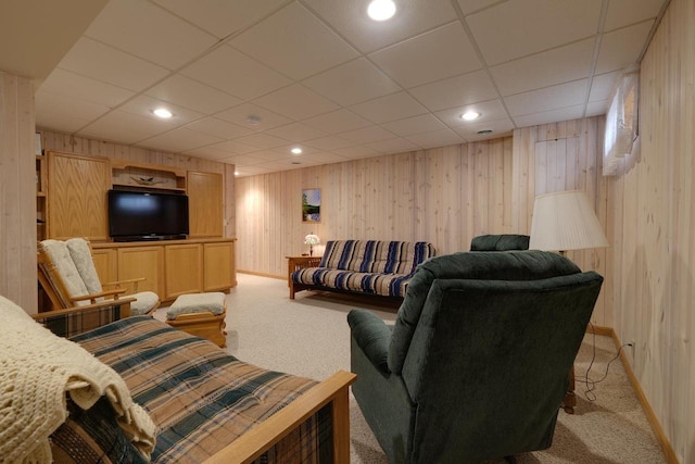 living room featuring light colored carpet, wooden walls, and baseboards