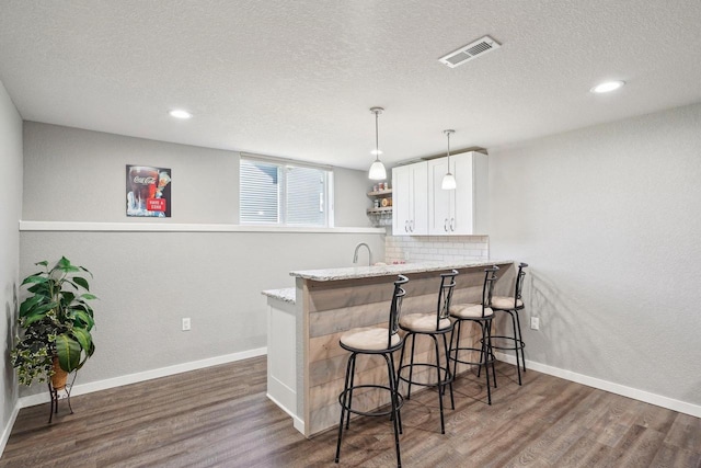 521 Dragon Willow Ln, Middleton, WI 53562 - bar area with dark wood-style floors, a textured ceiling, baseboards, backsplash, and recessed lighting