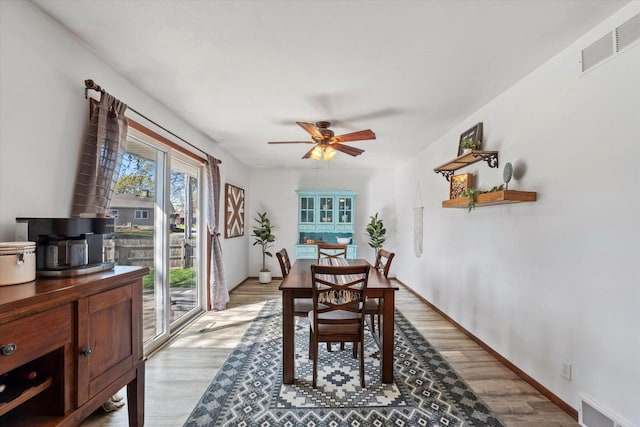 dining room with light wood-type flooring, baseboards, visible vents, and ceiling fan