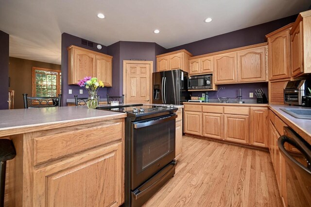 W157 Thomas Rd, Fountain City, WI 54629 - kitchen featuring black appliances, light brown cabinets, light wood-type flooring, and recessed lighting