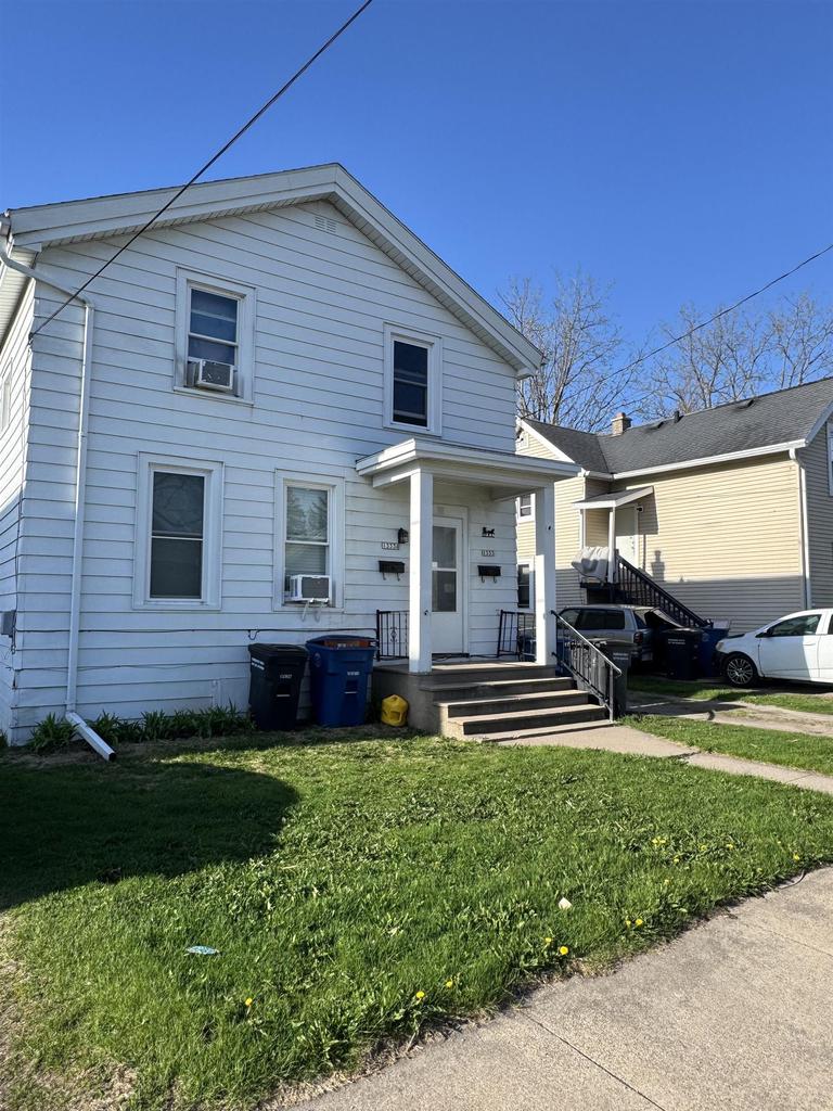 1333 Reed Ave, Oshkosh, WI 54901 - view of front facade with a front lawn, a porch, and cooling unit