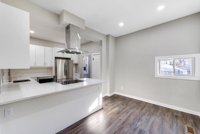 kitchen with stainless steel appliances, visible vents, a sink, island exhaust hood, and light countertops