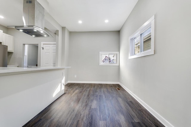 spare room featuring dark wood-type flooring, baseboards, and recessed lighting