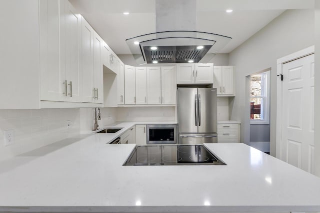 kitchen featuring backsplash, light countertops, appliances with stainless steel finishes, and a sink