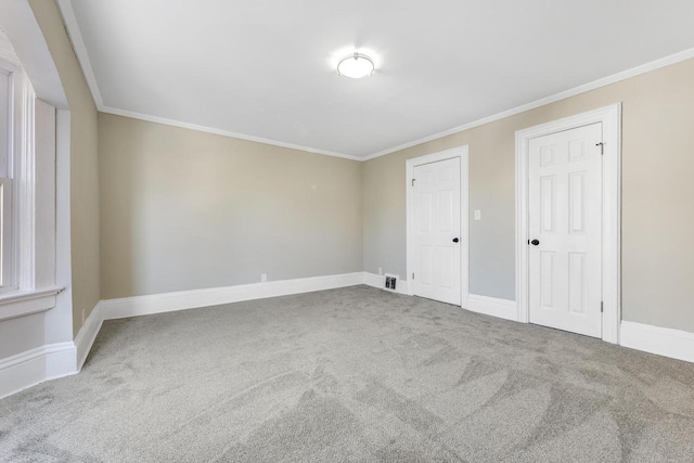 spare room featuring baseboards, ornamental molding, and carpet floors