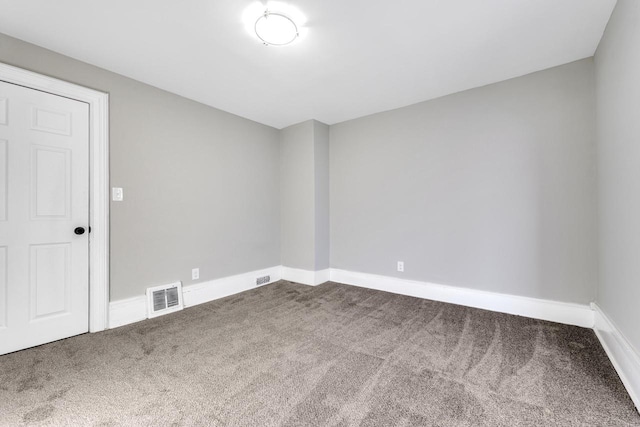 spare room with carpet floors, baseboards, and visible vents