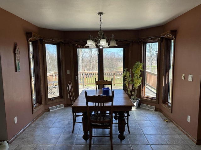 dining area featuring visible vents, baseboards, and a notable chandelier