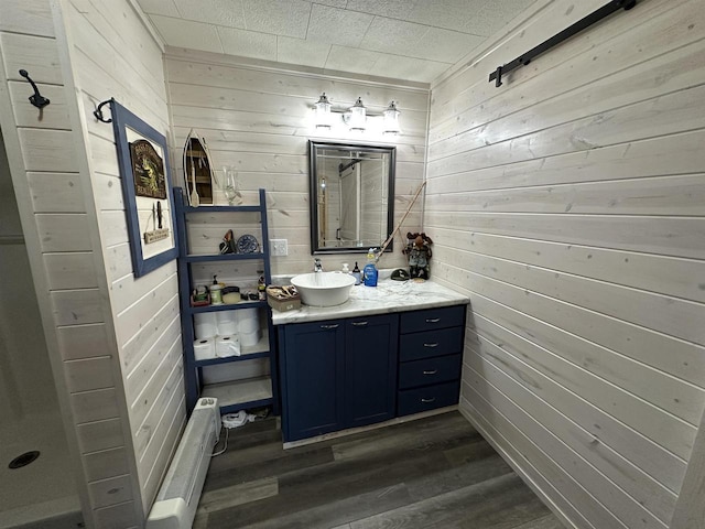 full bathroom featuring vanity, wood walls, a shower, and wood finished floors