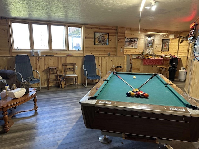 recreation room with billiards, wooden walls, and wood finished floors