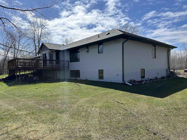 back of property with a deck and a lawn