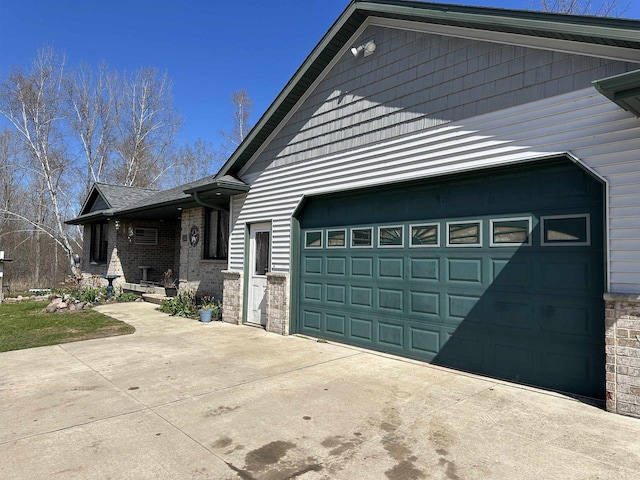 view of home's exterior featuring concrete driveway, brick siding, and an attached garage