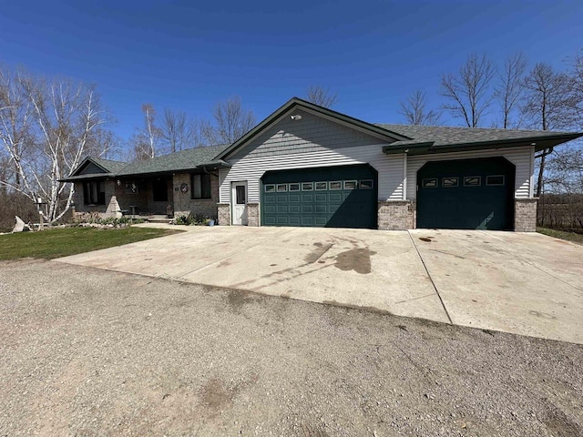 ranch-style house featuring an attached garage, a shingled roof, brick siding, and driveway