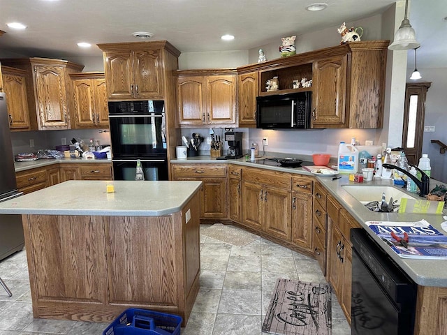 kitchen featuring a sink, black appliances, stone finish flooring, and brown cabinets