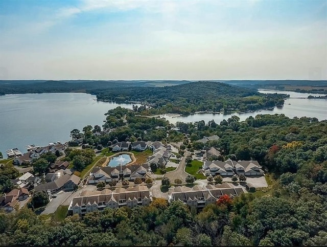 drone / aerial view with a water view, a residential view, and a view of trees