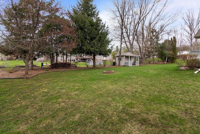 view of yard featuring a fire pit and fence