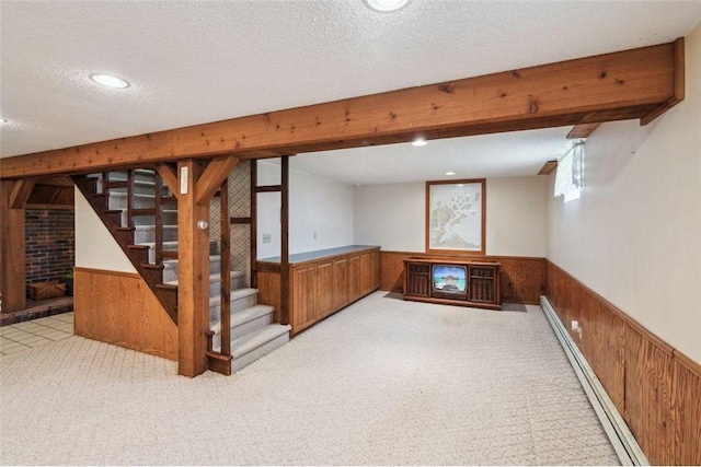 basement with stairs, wooden walls, a baseboard radiator, and a wainscoted wall