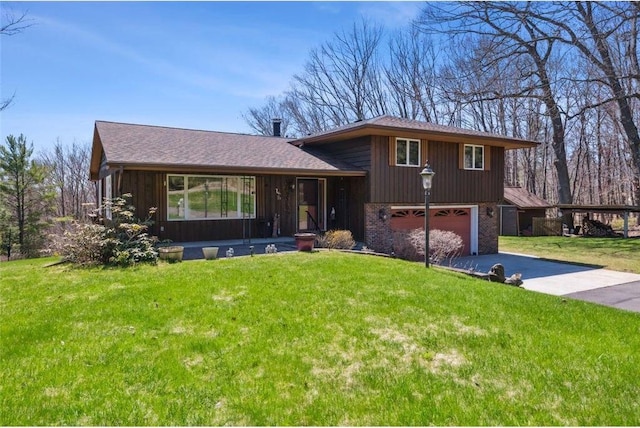tri-level home with a front lawn, driveway, and a garage