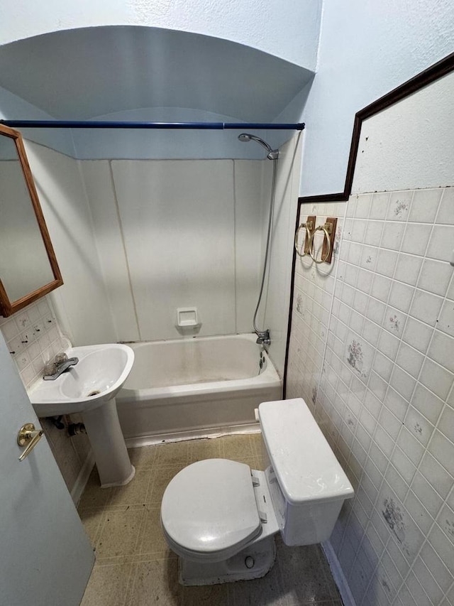 full bathroom featuring tile patterned floors, tile walls, toilet, and shower / bathing tub combination