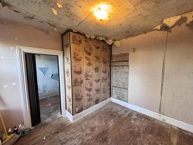 unfurnished room with baseboards and wood finished floors