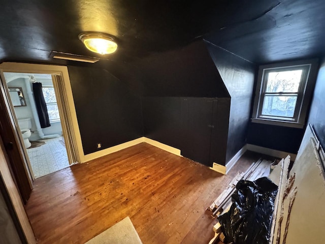 bonus room with vaulted ceiling, baseboards, and wood finished floors