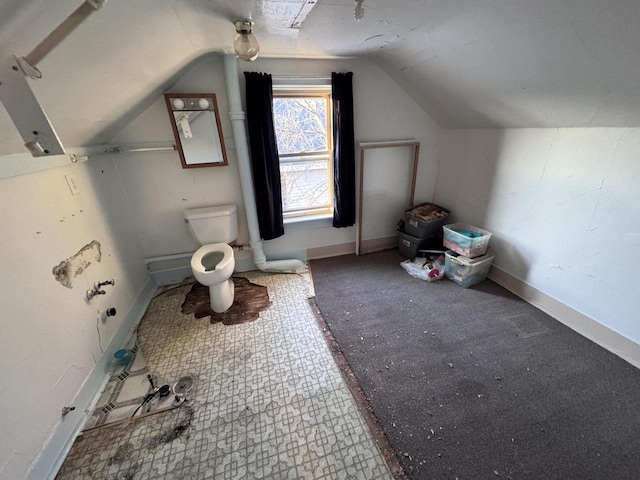 bathroom featuring lofted ceiling, baseboards, and toilet