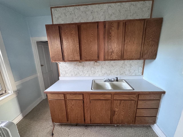 kitchen featuring a sink, light countertops, and brown cabinets