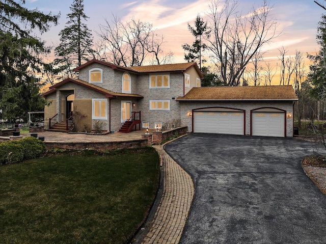 8408 N Lake Dr, Fox Point, WI 53217 - view of front of home featuring a lawn, brick siding, aphalt driveway, and a garage