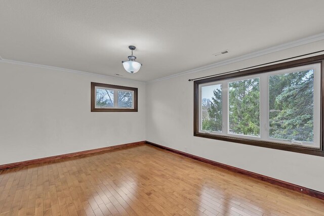 8408 N Lake Dr, Fox Point, WI 53217 - spare room featuring baseboards, ornamental molding, visible vents, and wood-type flooring