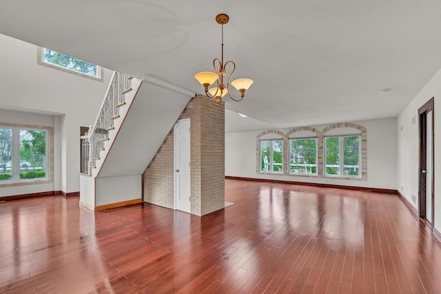8408 N Lake Dr, Fox Point, WI 53217 - unfurnished living room featuring baseboards, stairway, an inviting chandelier, and plenty of natural light