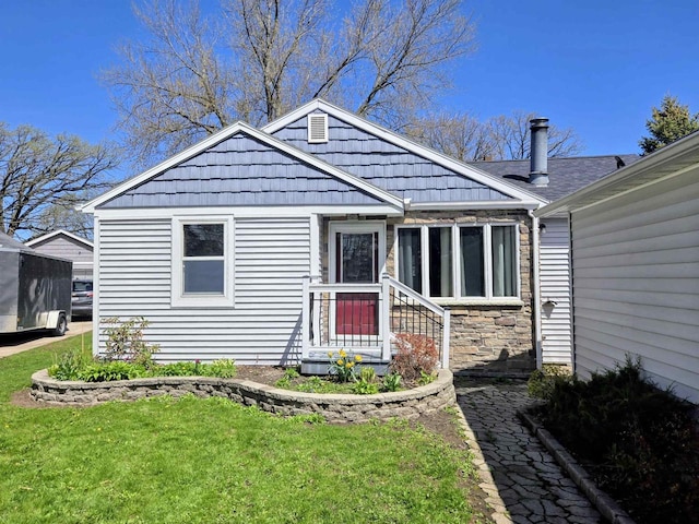 bungalow-style home featuring stone siding and a front yard