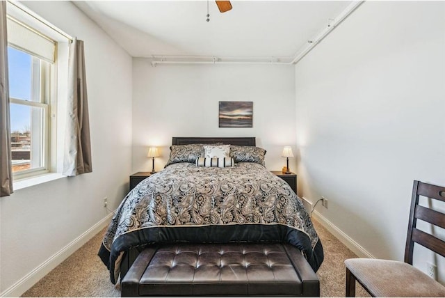 carpeted bedroom with baseboards and a ceiling fan