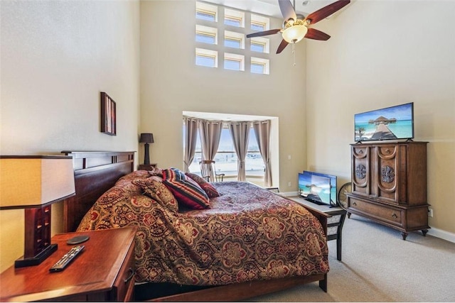 bedroom featuring carpet flooring, access to exterior, a high ceiling, baseboards, and ceiling fan