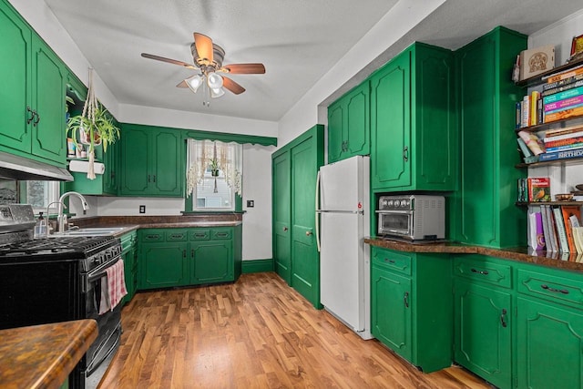 kitchen featuring a sink, freestanding refrigerator, light wood-type flooring, ceiling fan, and black range with gas cooktop