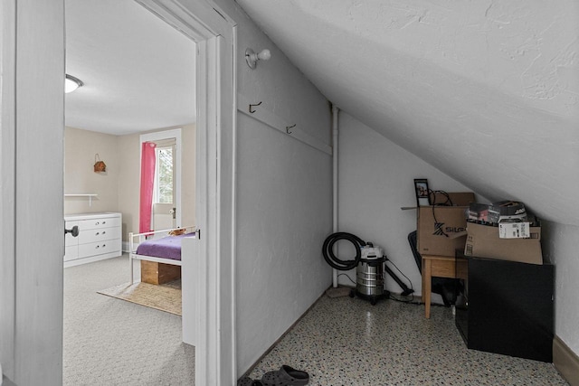 bonus room featuring lofted ceiling and speckled floor