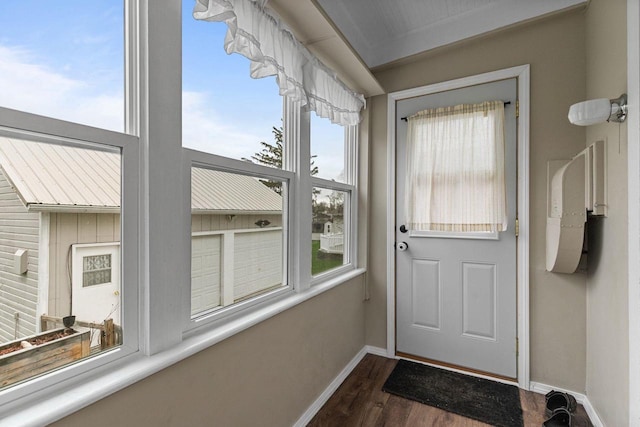 doorway to outside featuring a wealth of natural light, baseboards, and dark wood-style floors