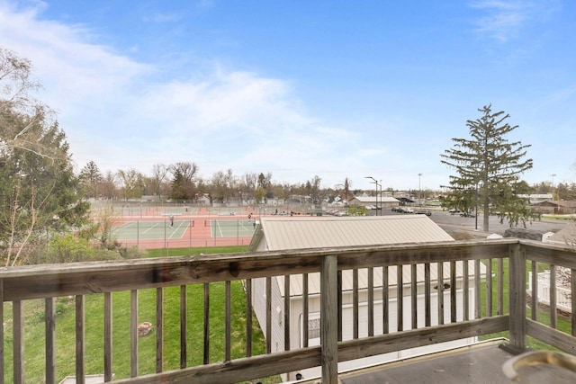 deck with a tennis court and fence