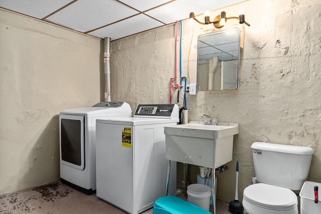 washroom featuring laundry area, washer and dryer, and a sink