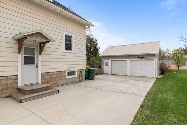 view of side of home featuring a yard, an outdoor structure, and a garage