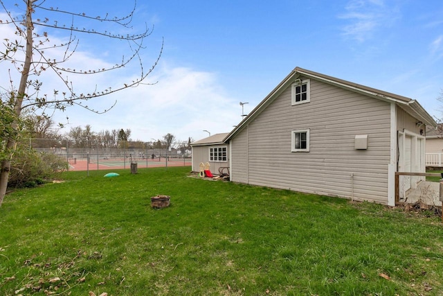 rear view of house featuring a yard and fence