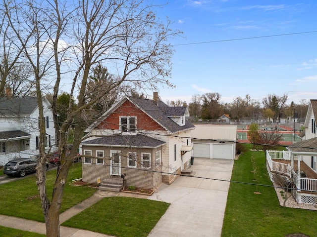 view of front of house with concrete driveway, a front yard, a chimney, and a garage