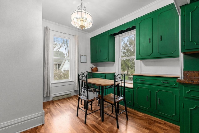 dining space with wood finished floors, ornamental molding, visible vents, a wealth of natural light, and a notable chandelier