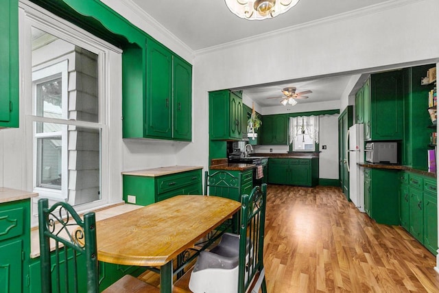 kitchen featuring freestanding refrigerator, ceiling fan, crown molding, green cabinetry, and light wood-type flooring