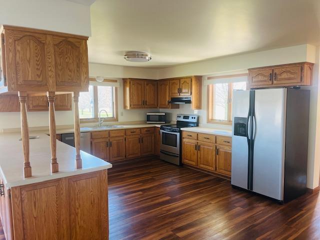 W8918 County Rd W, Crivitz, WI 54114 - kitchen with stainless steel appliances, under cabinet range hood, a sink, and brown cabinets