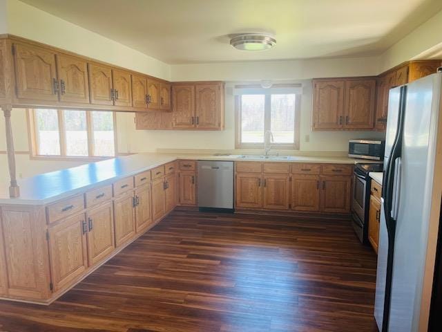 W8918 County Rd W, Crivitz, WI 54114 - kitchen with stainless steel appliances, a sink, dark wood-style floors, light countertops, and a peninsula