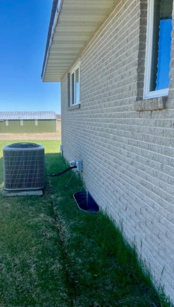W8918 County Rd W, Crivitz, WI 54114 - view of property exterior featuring central AC, brick siding, and a yard