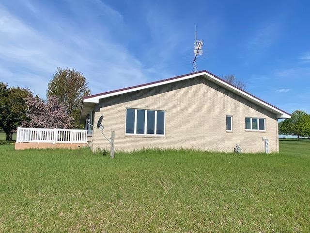 W8918 County Rd W, Crivitz, WI 54114 - view of property exterior featuring a yard, brick siding, and a deck