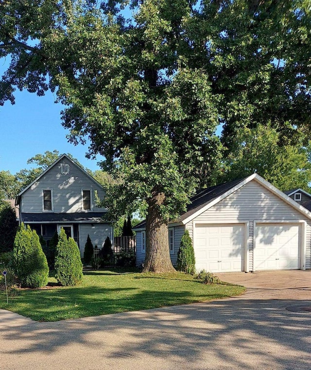 view of front of house with a front yard and a detached garage