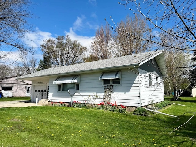 view of front of house featuring an attached garage, concrete driveway, roof with shingles, and a front lawn