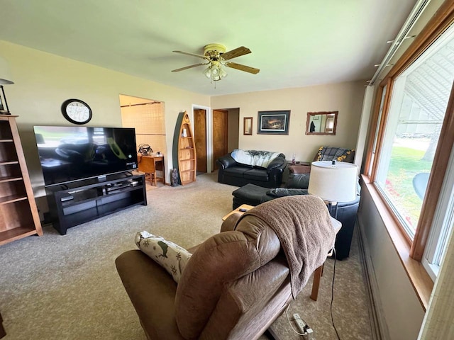 carpeted living area with ceiling fan